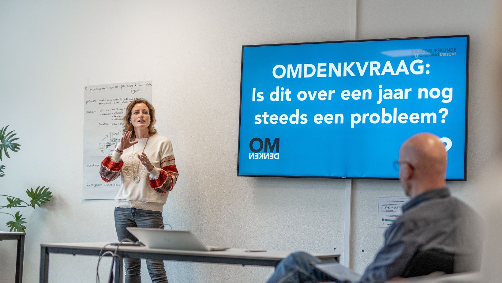 Student voor de klas en docent Gert Jan Schop bij afstudeermodule Strategisch Onderzoek en iIplementatie BKOU